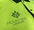 Close-up of a high-visibility yellow work shirt with the Mount King Landscapes logo printed on the chest, featuring a leaf and mountain design.