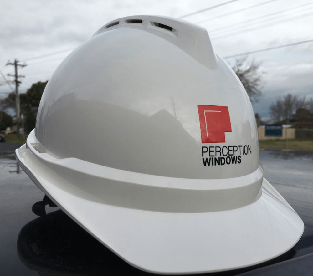 White hard hat with the Perception Windows logo printed on the front, featuring a red square window icon and black text.