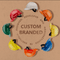 **Alt Text:** Circle of colourful custom branded hard hats – designed and manufactured in Australia, available with free logo printing and no minimum order.