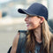 Smiling woman wearing a navy performance cap with mesh side panels – ideal for custom branded caps for clubs, events, and activewear promotions in Australia.