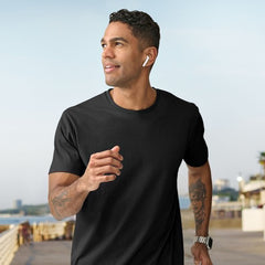 **Alt Text:** Man running along the beach wearing black custom T-shirt – personalised activewear with free logo included, perfect for events, teams, and casual uniforms.