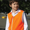 **Alt Text:** Young student wearing orange hi-vis vest outdoors – custom printed safety vest with free logo included, ideal for schools and events.