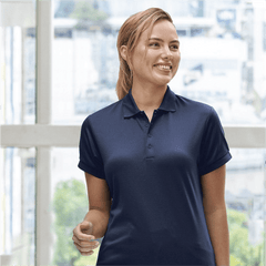 **Alt Text:** Smiling woman wearing navy custom polo shirt – personalised uniform with free printed logo included, ideal for workwear and team branding.